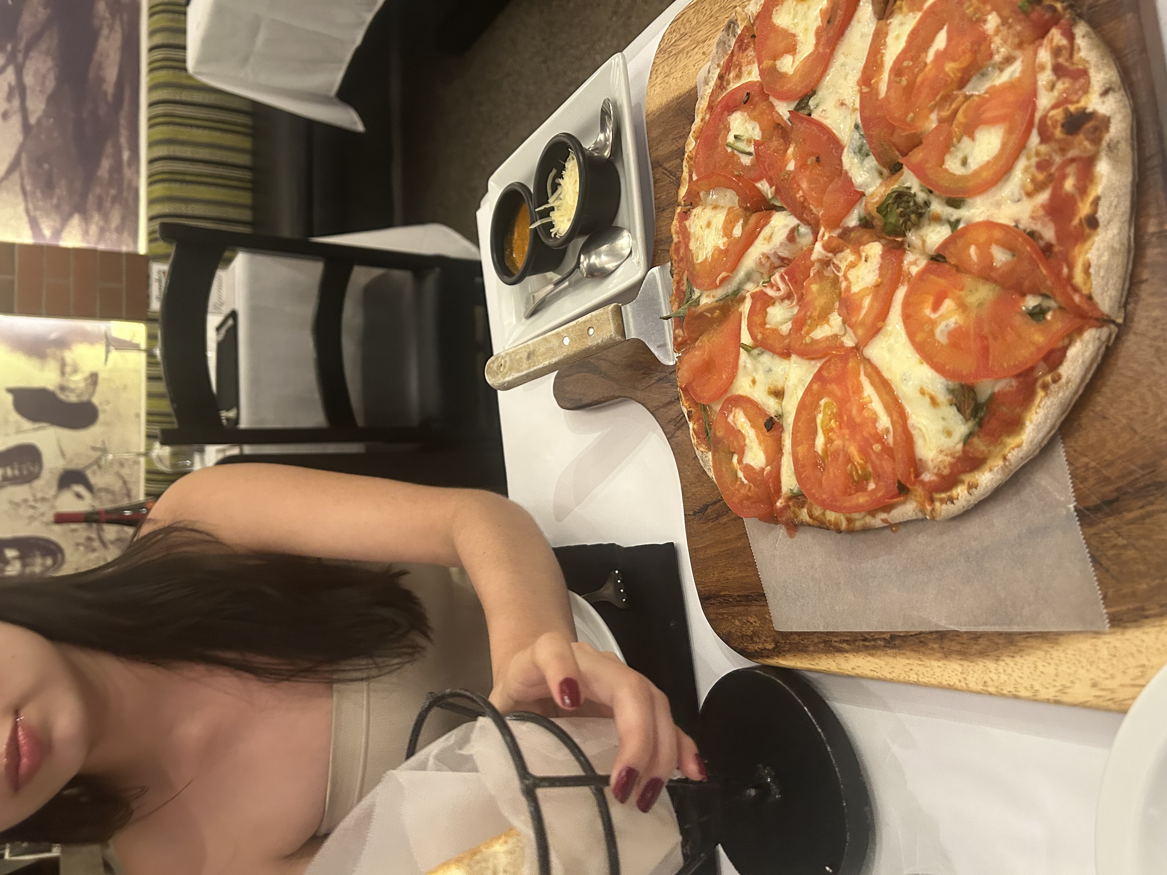 A romantic restaurant dinner with a margherita pizza on a wooden board